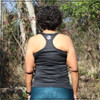 This is the back of the Strong Athletic Grown-Ass Woman Racerback Performance Wicking Tank. The material on the back cuts in quite a bit, so that you see much of the shoulder blades. If you have a super strappy bra (like the one that the athlete in the photo is wearing) you'll probably see it. This black exercise tank is one of our favorites. 