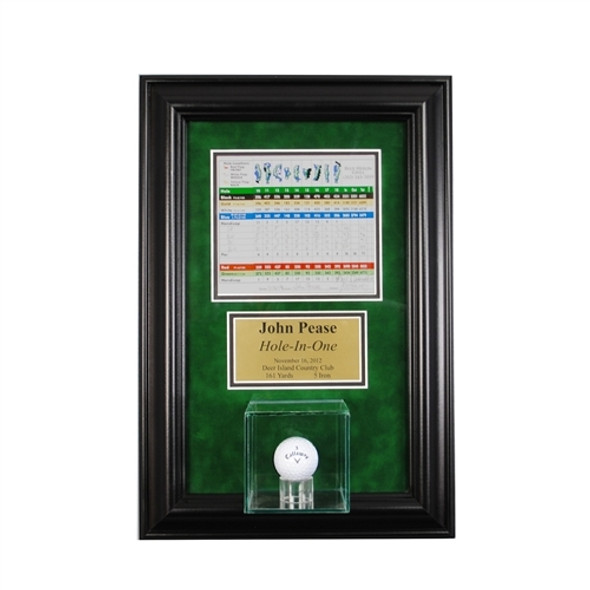 hole in one display with a golf ball and scorecard over green backing with black frame