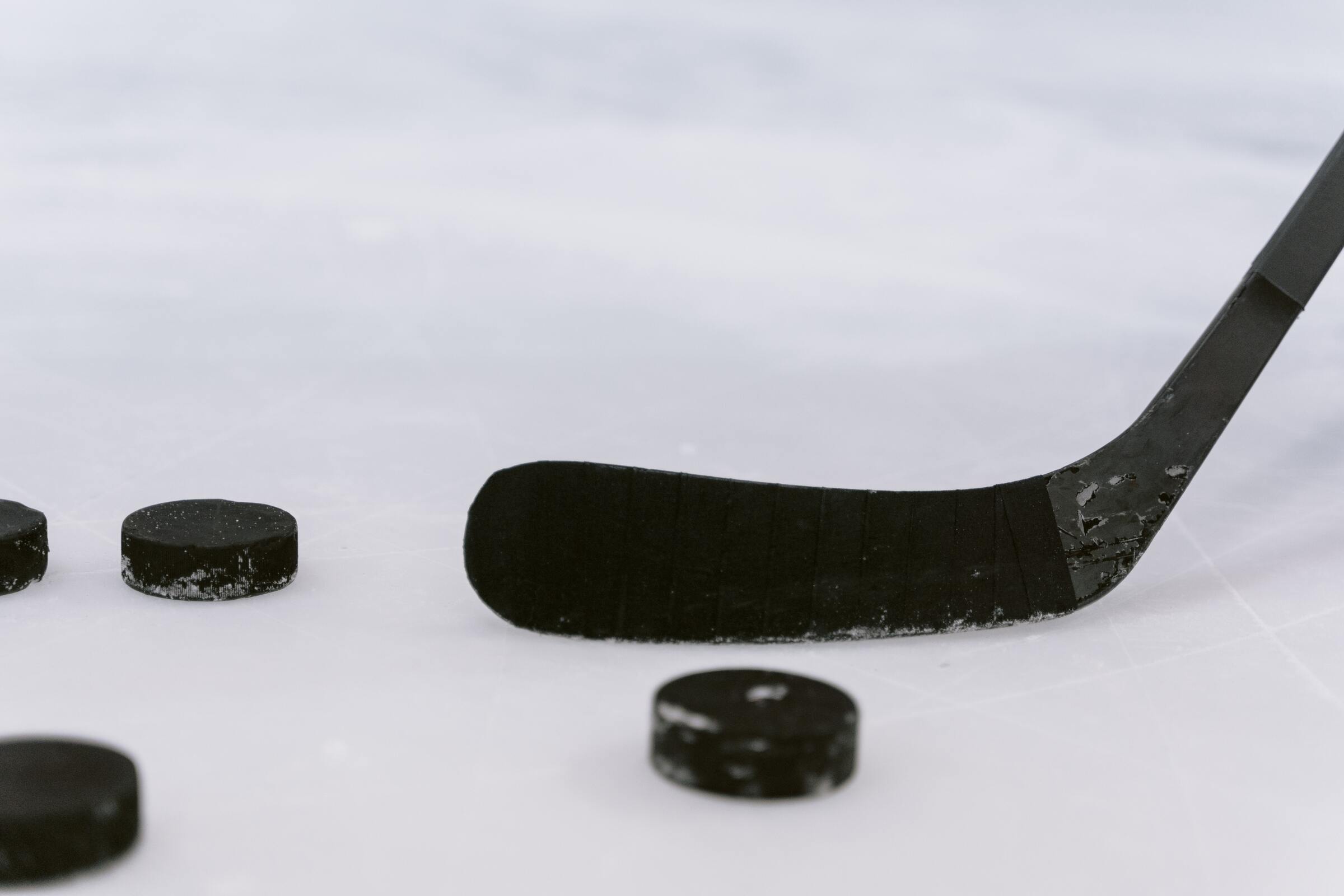 hockey stick and pucks on ice