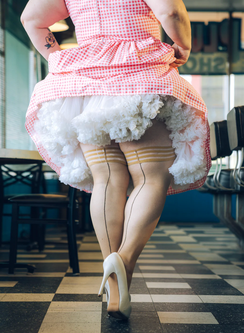 Woman wearing frilly skirt showing Kix'ies retro thigh high stockings. Plus size Cuban heel stay up stockings with black back seam and 3 band silicone tops. Woman wearing frilly skirt showing Kix'ies retro thigh high stockings. Plus size Cuban heel stay up stockings with black back seam and 3 band silicone tops.