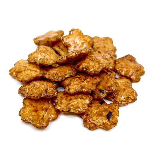 **Image Alt Text:**
A pile of soy-glazed rice crackers shaped like flowers, displayed on a white background. These Japanese-style snacks have a glossy, caramelized brown surface with slight charring and a crunchy texture, often associated with a savory and slightly sweet flavor.