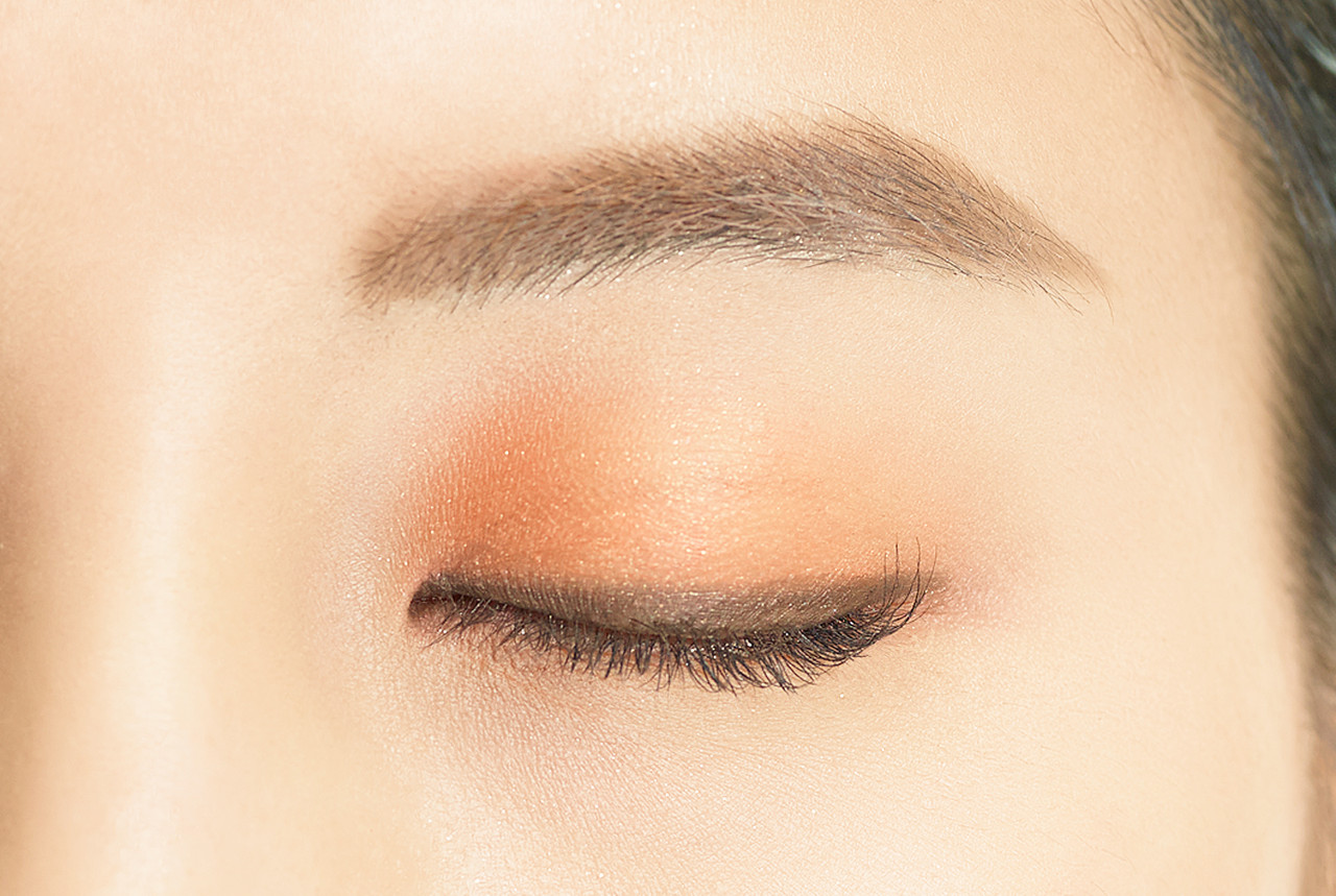 Image showing Dual Colour Stick in BR02 Autumn Shade applied to the eye. There is a line of dark brown close to the lash line, with a light wash of orangey gold over the rest of the lid creating a gradient effect.