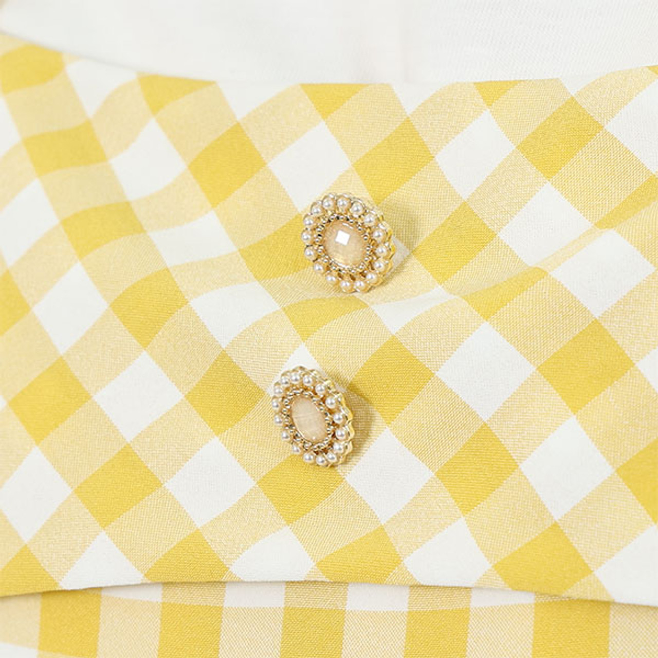 A close up of the buttons on the yellow dress.