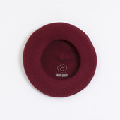 The inside of the burgundy beret showing the Mary Quant logo and daisy printed inside.