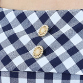 A close up of the buttons on the navy dress.