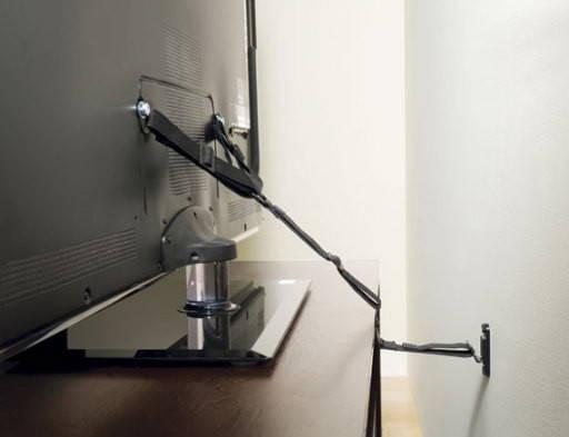 Closeup of adjustable Sanus ELM701 strap connecting furniture to wall with included adhesive anchors