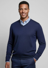 A navy knitted jumper with a V-neck and fitted cuffs, worn over a light blue collared shirt. Features a logo.