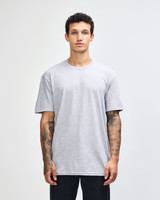 A woman wearing a grey unisex fine jersey short sleeve t-shirt. The shirt features a logo on it.