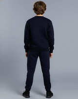 Kid's fleecy trackpants in navy, featuring cuffs, knee padding, and a logo. Worn with a matching navy top.