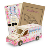A pink and white wooden ice cream van model kit with assembly instructions and parts.