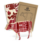 A wooden model of a cow in red and cream, featuring anatomical cuts, accompanied by two instructional booklets.