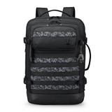 A black backpack with a patterned front panel and multiple pockets. It features adjustable straps and a logo.