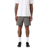 A pair of grey dress shorts worn by a person with tattoos, standing in a casual outfit.
