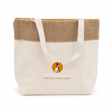 A jute and cotton cooler bag in cream and tan with a logo on the front, featuring sturdy handles.