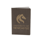 A dark grey eco notebook with a textured cover and a logo on the front. It features gold lettering and branding.