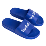Blue PVC slides with a wide strap featuring a logo. The slides have a smooth, glossy finish.