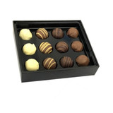 A black box containing twelve assorted chocolate truffles in various flavours, including white and dark chocolate.