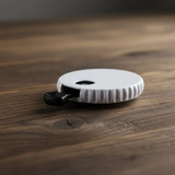 A drink bottle opener in white with a textured grip, resting on a wooden surface. It features a logo.