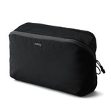 A black packing cube with a zippered mesh top, featuring branding on the front.