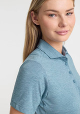 A women's short sleeve polo in a soft blue colour, featuring a collar and buttons, with a logo on the front.