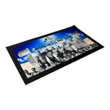 A bar mat in black featuring a group photo on a beach background with blue and white elements. It has a logo.