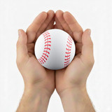 A white baseball with red stitching held between two hands. The hands are open, supporting the ball gently.