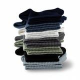 A stack of Breathe Fit Socks in various colours, including navy, green, grey, white, and black. The socks have a ribbed texture.