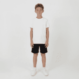 Youth Core Shorts in black, worn by a boy in a plain white t-shirt and white sneakers, standing against a plain background.