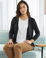 A dark grey, women's 100% merino wool long sleeve cardigan with buttons, worn over a white blouse.