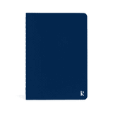 A navy blue softcover pocket journal with a logo on the bottom corner.