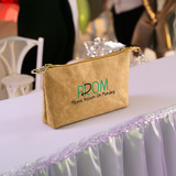 A brown Kraft paper cosmetic bag with a zip closure and a logo featuring green text.