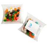 Transparent pillow packs filled with colourful jelly beans, featuring various shades including black, white, orange, green, and pink.
