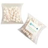 A pillow pack containing white mints, featuring a branded sticker on one side. The pack is transparent and square.