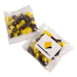 Colourful humbug sweets in a branded bag, featuring yellow and dark brown candy pieces.