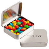 A rectangular metal tin filled with colourful chewy fruit sweets, in red, green, blue, and yellow.