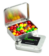 A rectangular tin filled with colourful Skittles, featuring a lid and a branding sticker on the front.