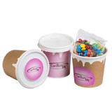 A coffee cup with a pastel pink design and a lid, containing a packet of colourful M&Ms. Features a logo.