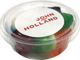 A tub filled with mixed lollies, featuring various vibrant colours, encased in clear plastic with a branded lid.