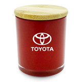 A medium red candle with a bamboo lid and a logo on the front.