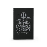 A black notebook featuring a hot air balloon design and the text "Little Learners Academy".