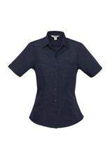A navy blue women's button-up shirt with short sleeves and two front pockets. It features a logo on the label.