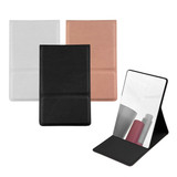 A compact mirror featuring a black, white, and rose gold exterior, with a standing design and reflective surface.