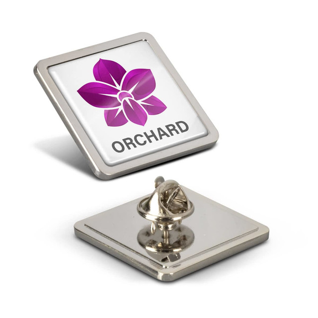 A square lapel pin in silver featuring a purple flower design, with a backing for attachment.