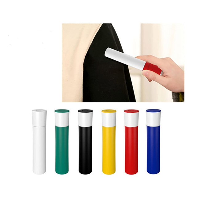 A lint brush in various colours including white, green, black, yellow, red, and blue, displayed with a hand using one.