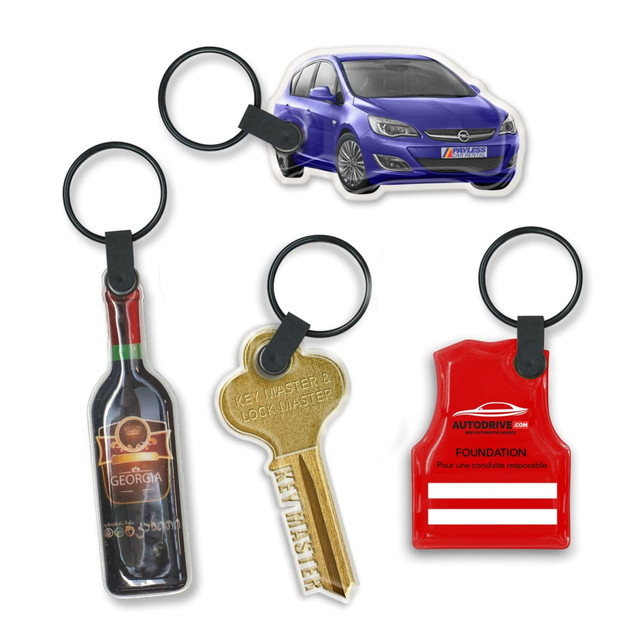 A collection of four key rings, including a car, a wine bottle, a key, and a red vest, all on black rings.