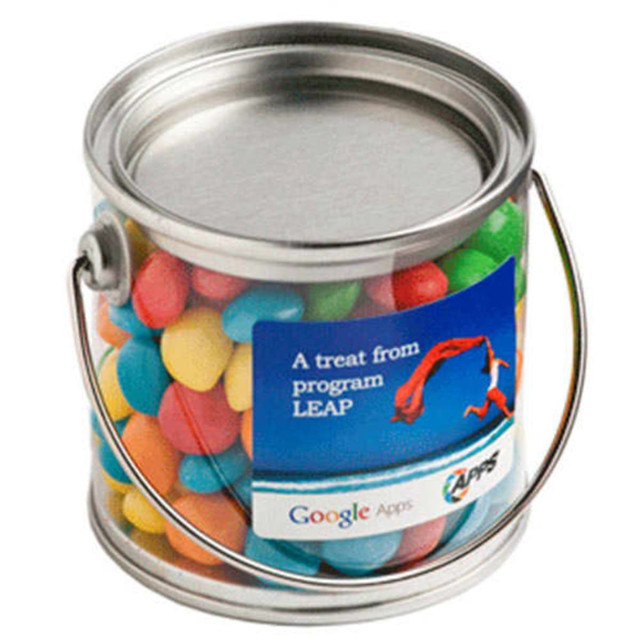 A small silver bucket filled with colourful chewy fruit candies, featuring a handle and a logo on the side.