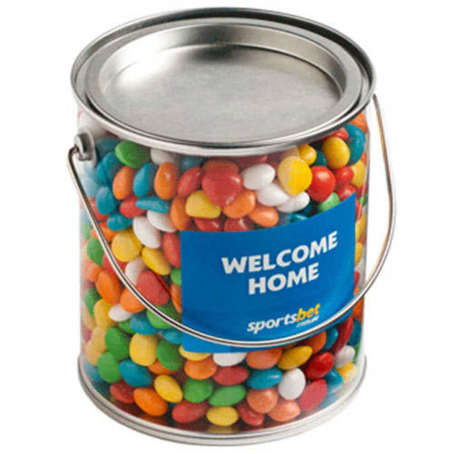 A large PVC bucket filled with colourful chewy fruits in various shades, featuring a handle and a branding label.
