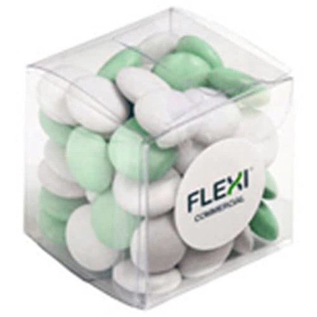 A clear cube container filled with green and white chocolate beans, featuring a logo on the front.