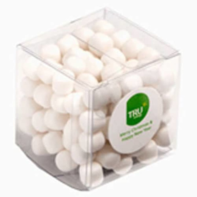 A transparent cube container filled with white chewy mints. Features a logo on the front of the packaging.
