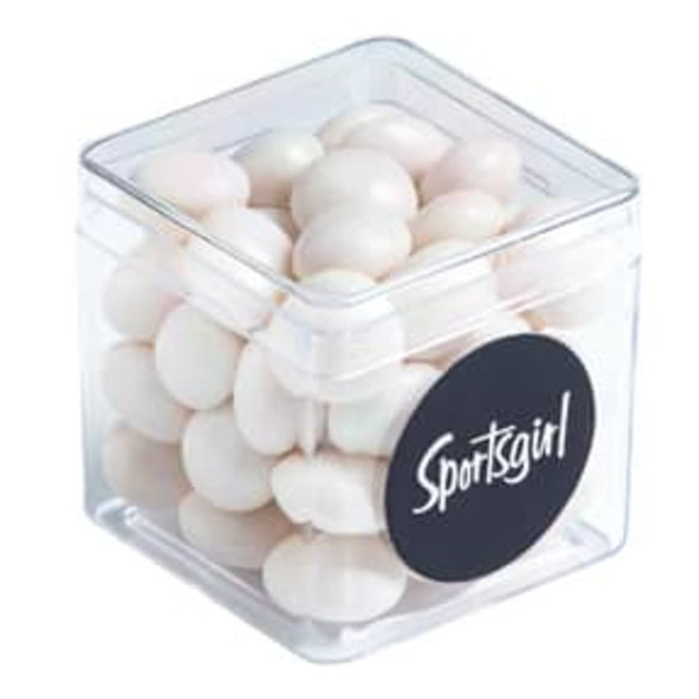 A clear cube container filled with white chewy mints, featuring a circular black logo.